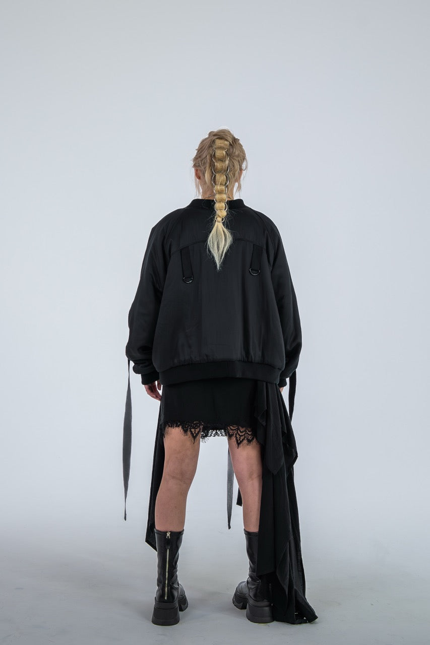 Person wearing a black outfit with a skirt and boots on a white background