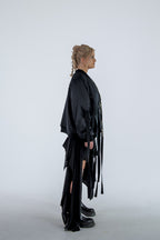 Person wearing a black outfit with flowing sleeves and skirt on a white background
