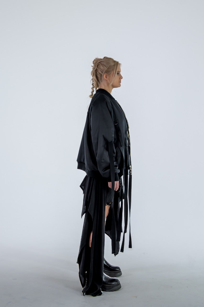 Person wearing a black outfit with flowing sleeves and skirt on a white background