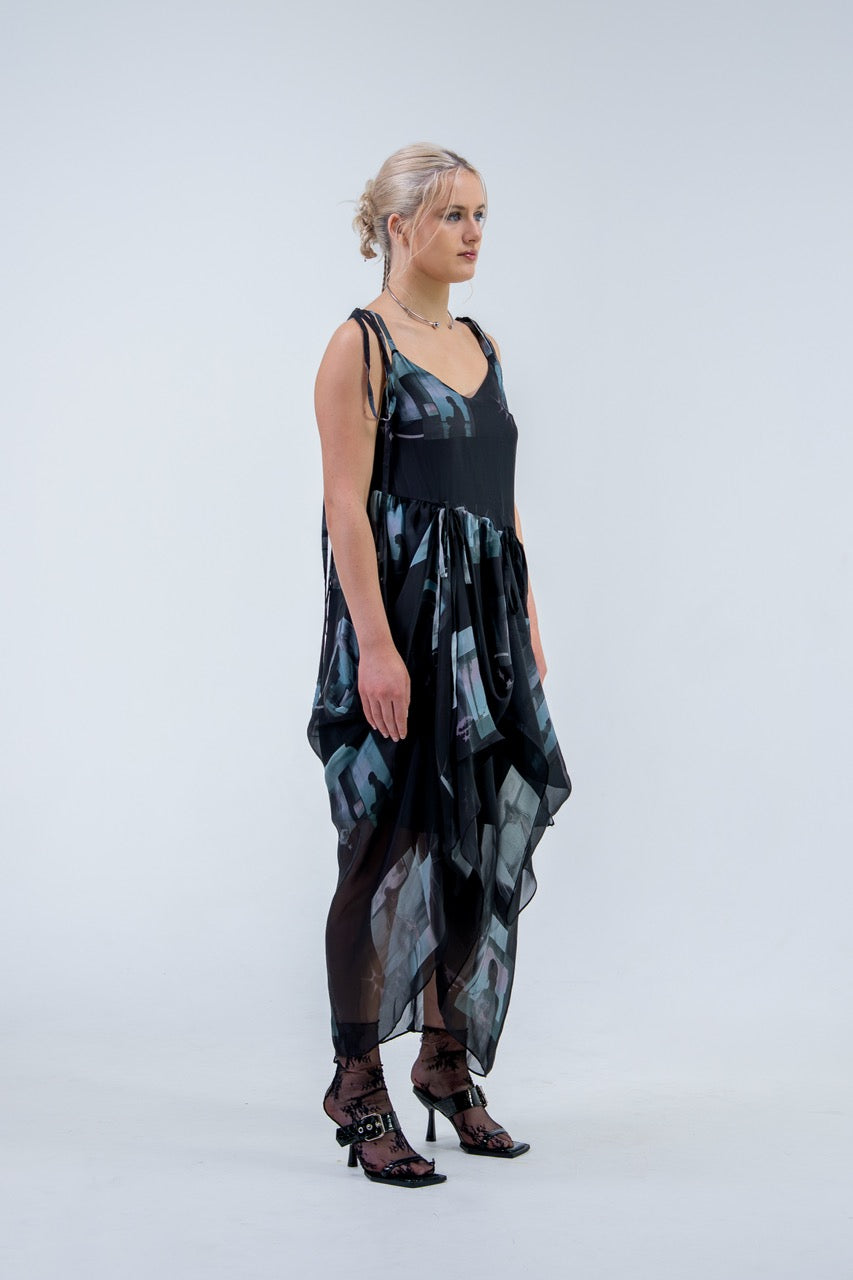 Woman wearing a black and gray Rhian silk patterned dress on a white background