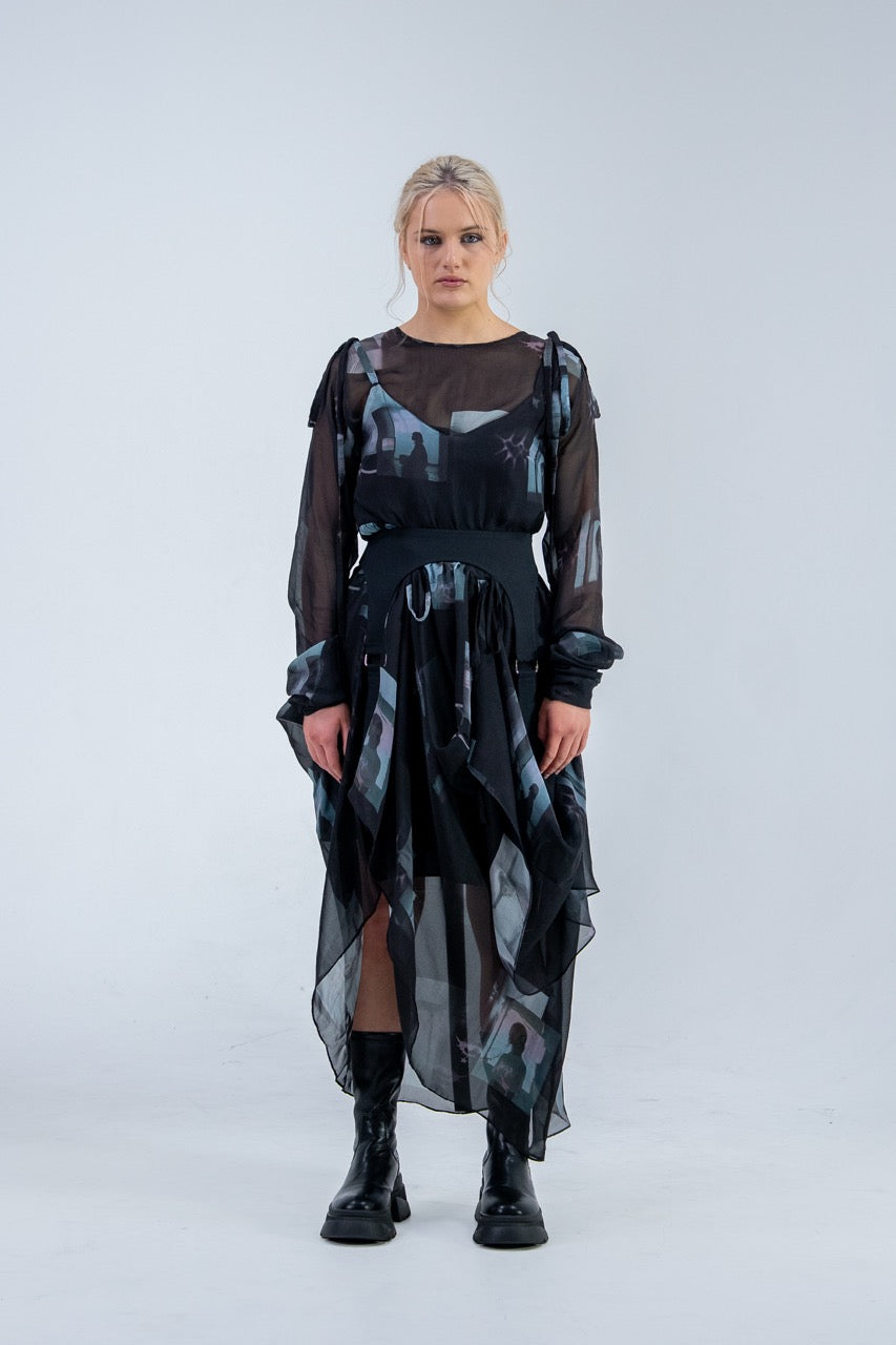 Woman wearing a black and gray Rhian silk patterned dress on a white background