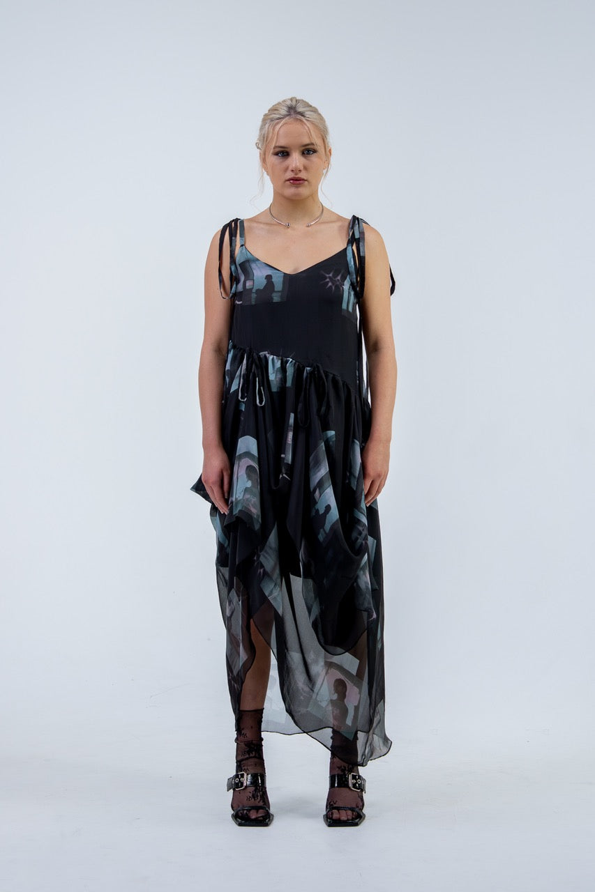 Woman wearing a black and gray Rhian silk patterned dress on a white background