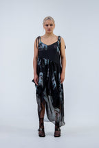 Woman wearing a black and gray Rhian silk patterned dress on a white background