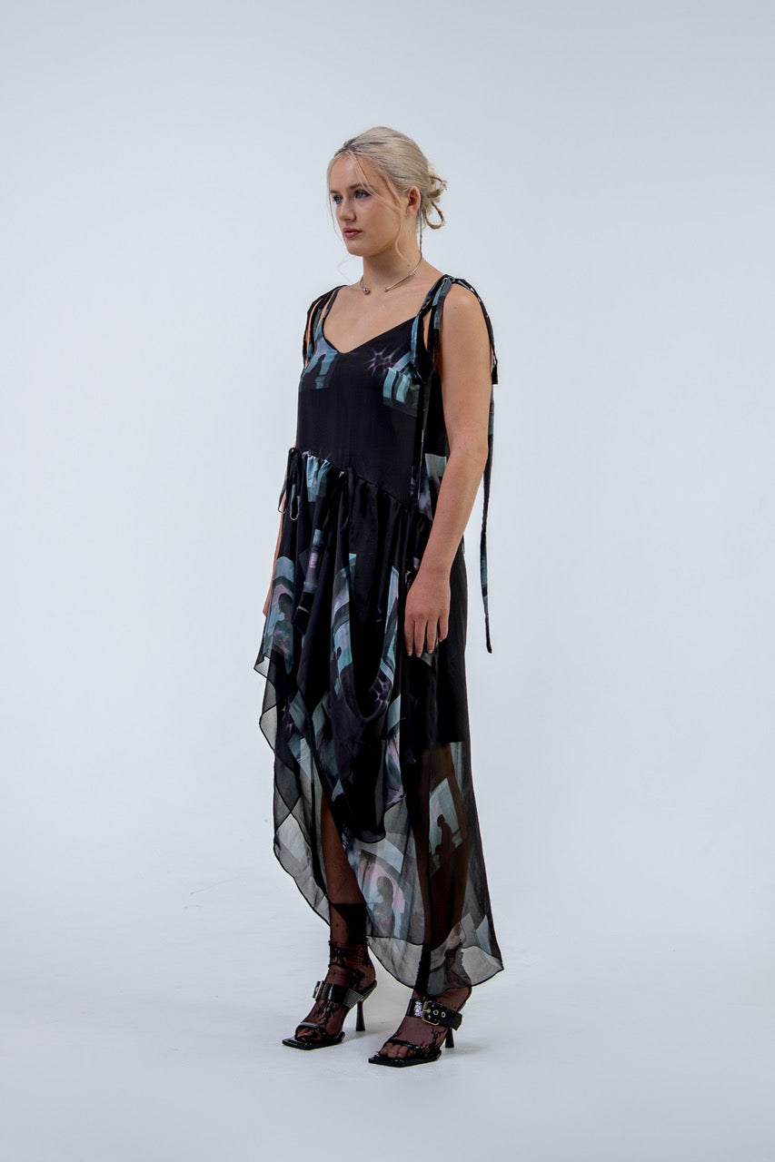 Woman wearing a black and gray Rhian silk patterned dress on a white background