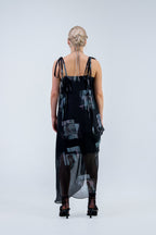 Woman wearing a black and gray Rhian silk patterned dress on a white background