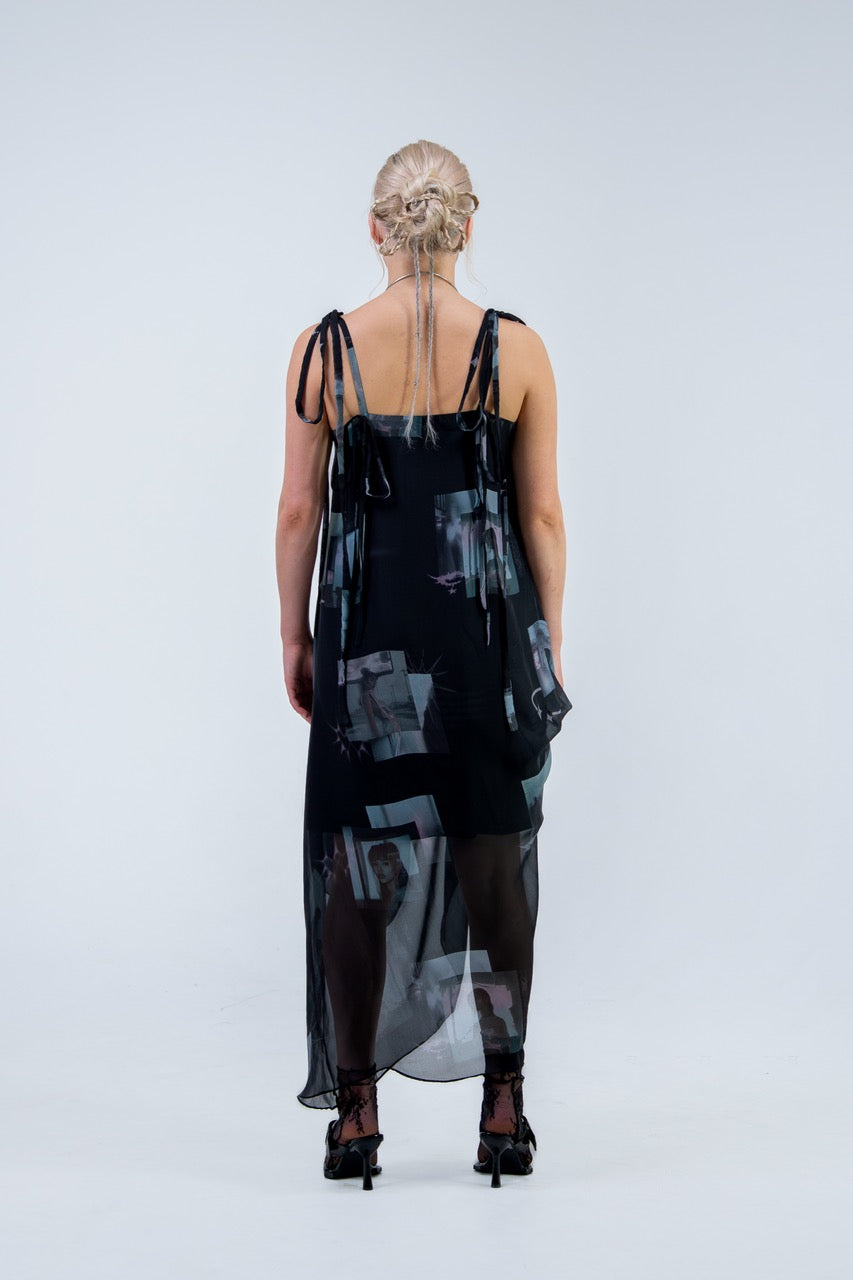 Woman wearing a black and gray Rhian silk patterned dress on a white background