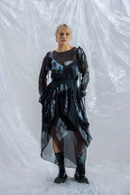 Woman wearing a black and gray Rhian silk patterned dress on a white background
