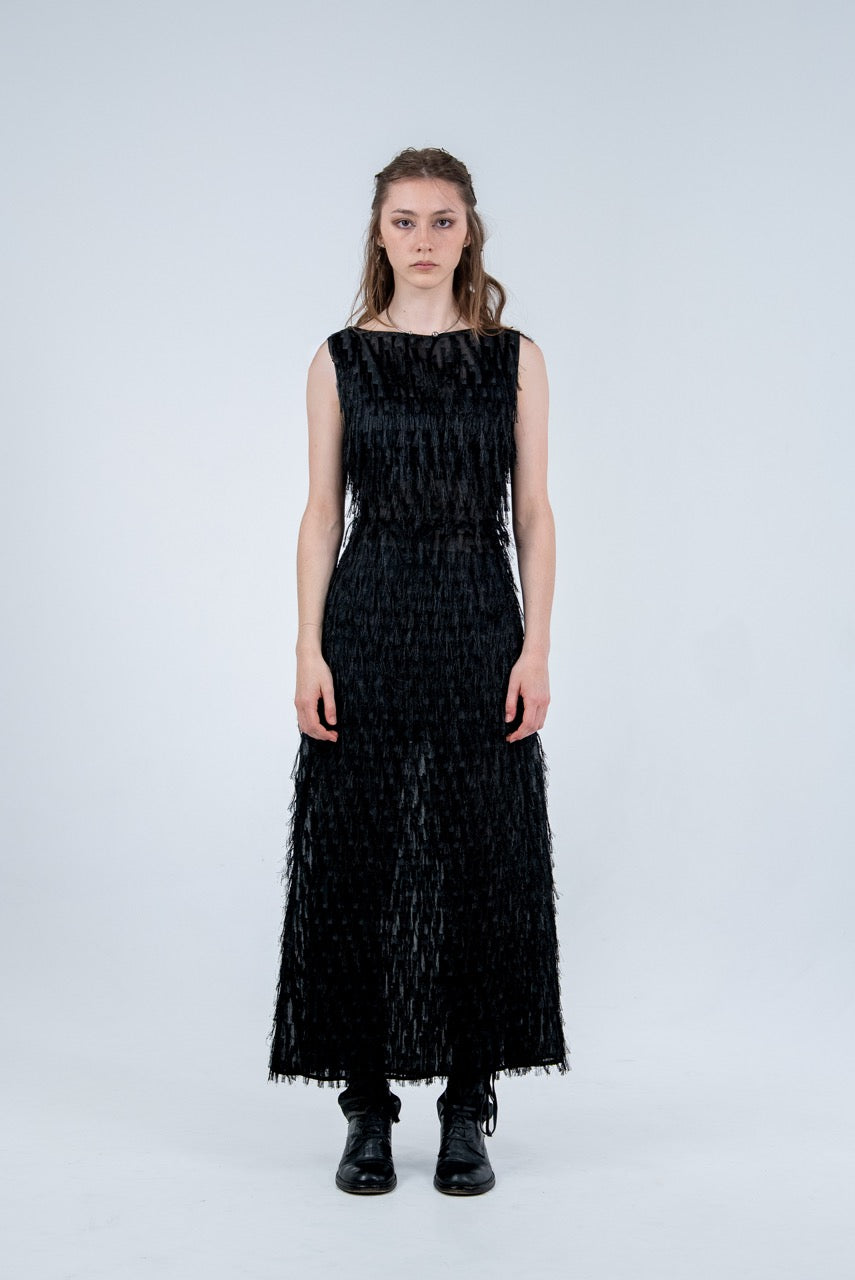 Woman wearing a black dress with textured pattern on a white background