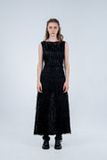 Woman wearing a black dress with textured pattern on a white background