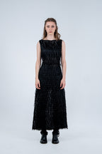 Woman wearing a black dress with textured pattern on a white background