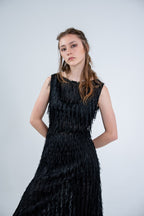 Person wearing a black sleeveless dress with fray details handmade by Rhian in Dunedin on a white background