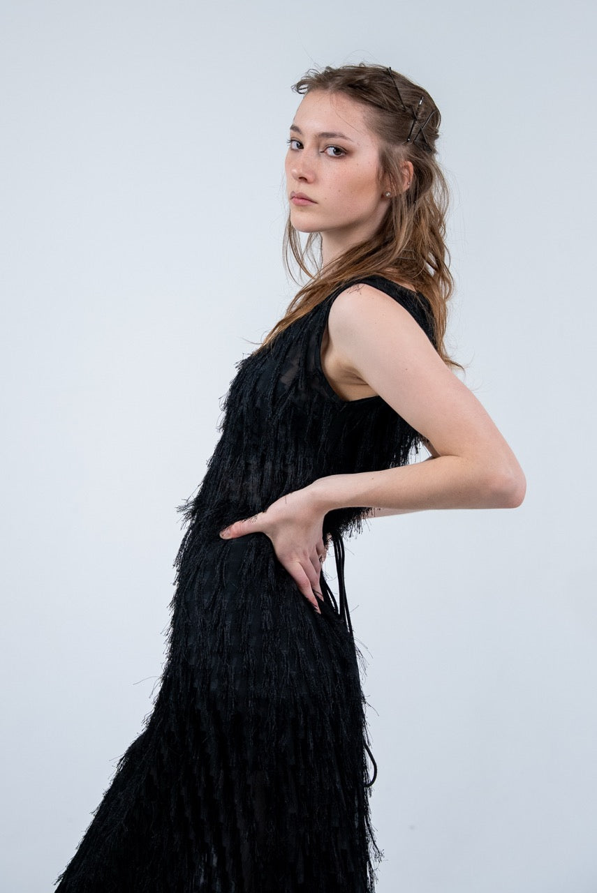 Person wearing a black sleeveless dress with fray details handmade by Rhian in Dunedin on a white background