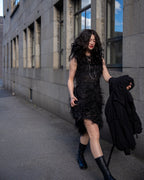 Person wearing a black sleeveless dress with fray details handmade by Rhian walking on a Dunedin street