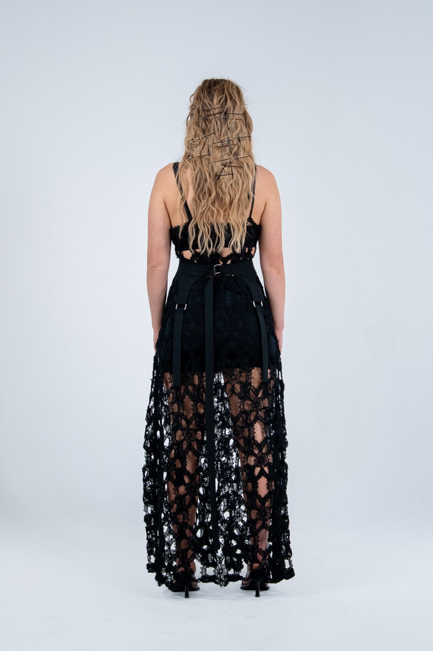Woman wearing a black lace dress by Rhian on a white background