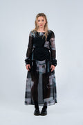 Woman wearing a Rhian long, dark dress with abstract patterns on a light gray background