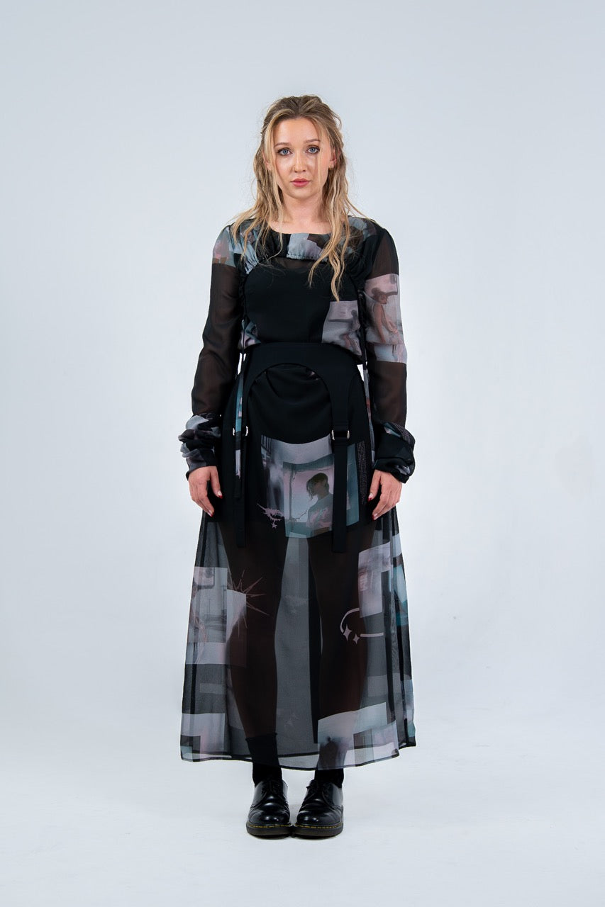 Woman wearing a Rhian long, dark dress with abstract patterns on a light gray background