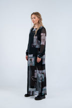 Woman wearing a Rhian long, dark dress with abstract patterns on a white background