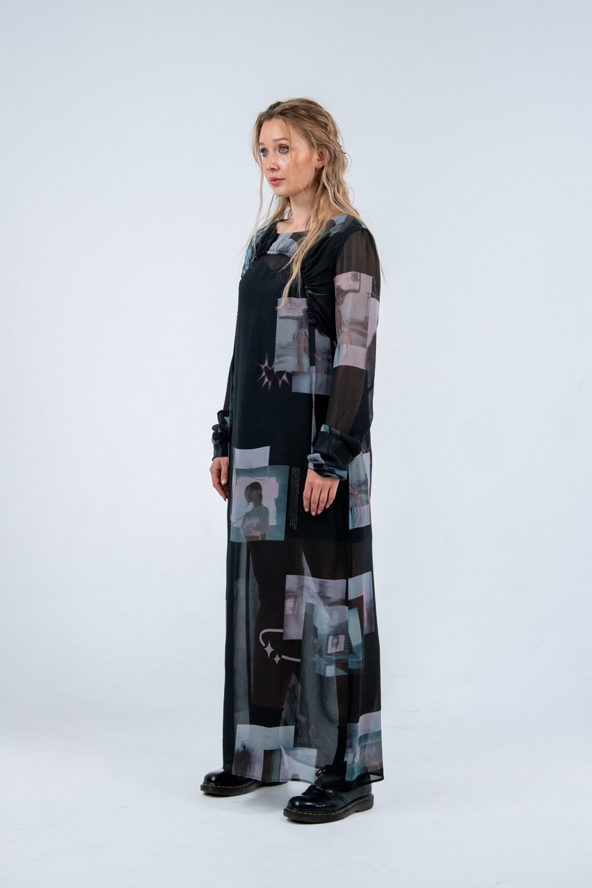 Woman wearing a Rhian long, dark dress with abstract patterns on a white background