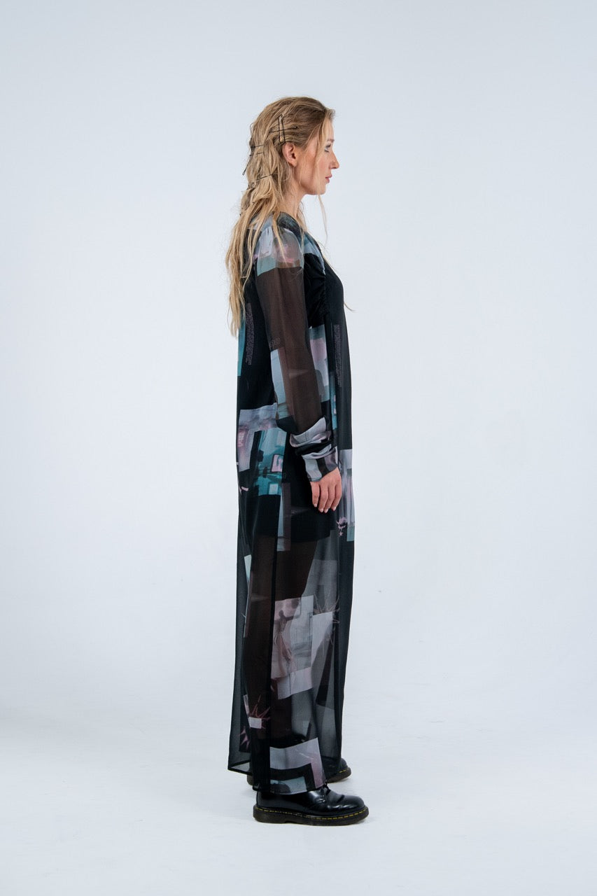 Woman wearing a long, dark-colored dress with abstract patterns on a white background