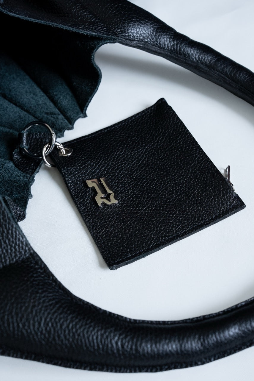 Black leather wallet with chrome Rhian emblem on a white surface