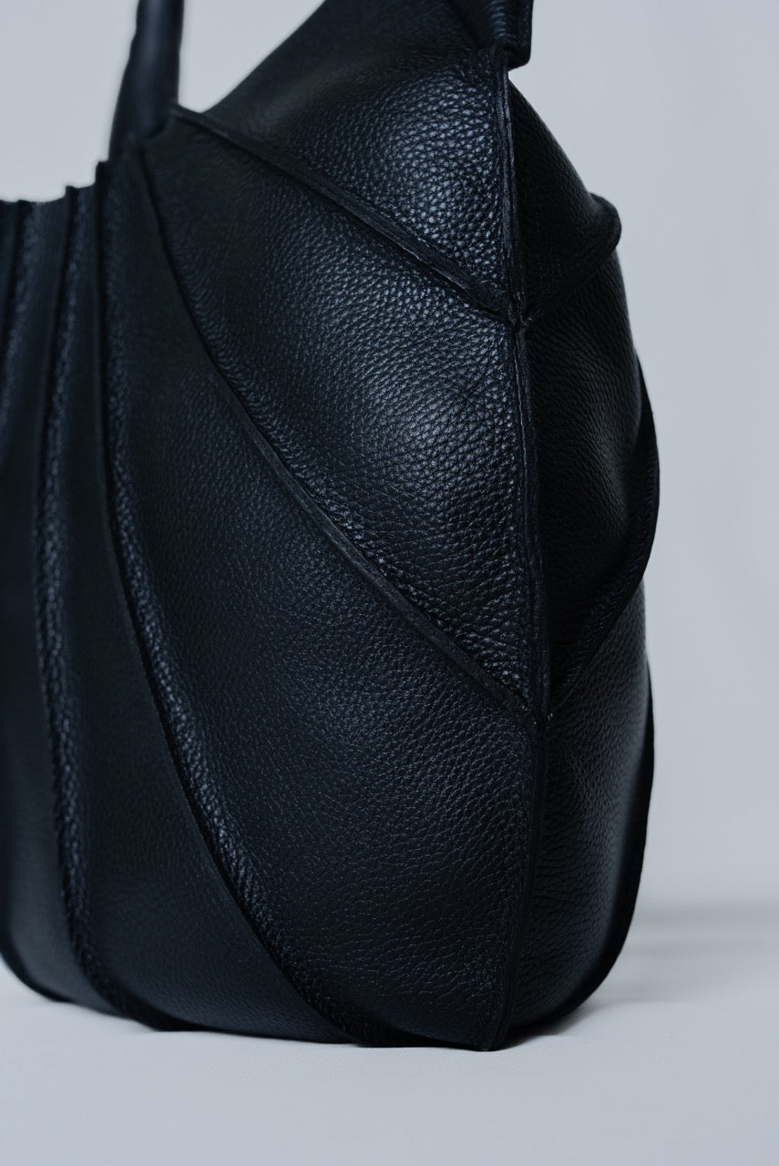 Black leather handbag on a light gray background
