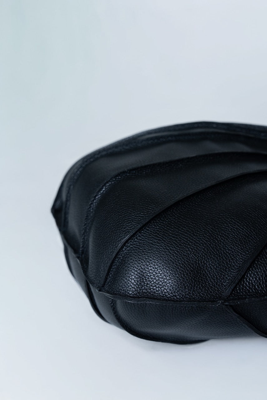 Black leather bag on a light gray background