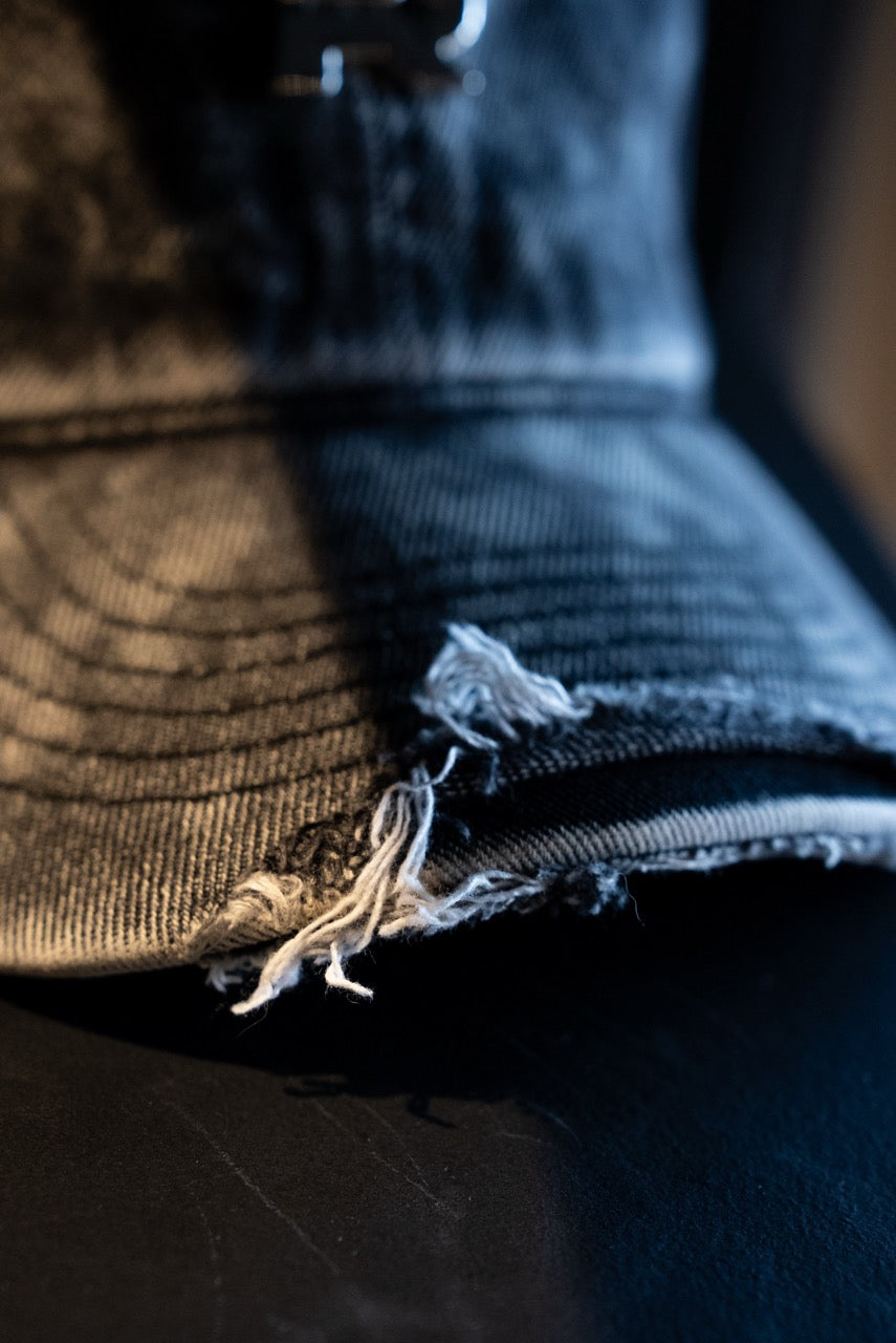 Close-up of a worn-out denim hat with frayed edge