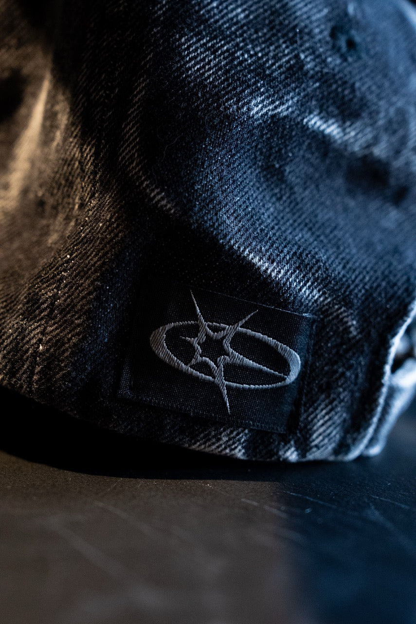 Close-up of a dark blue cap with a logo on a dark surface