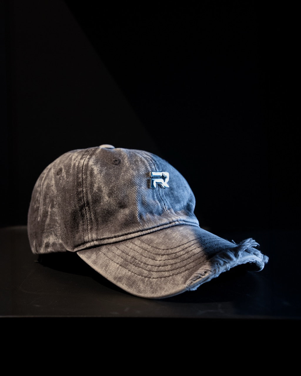 Washed denim cap with a logo on a black background