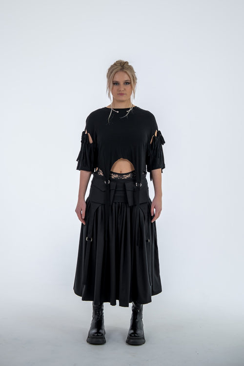 Person wearing a black outfit with cut-out details on a white background