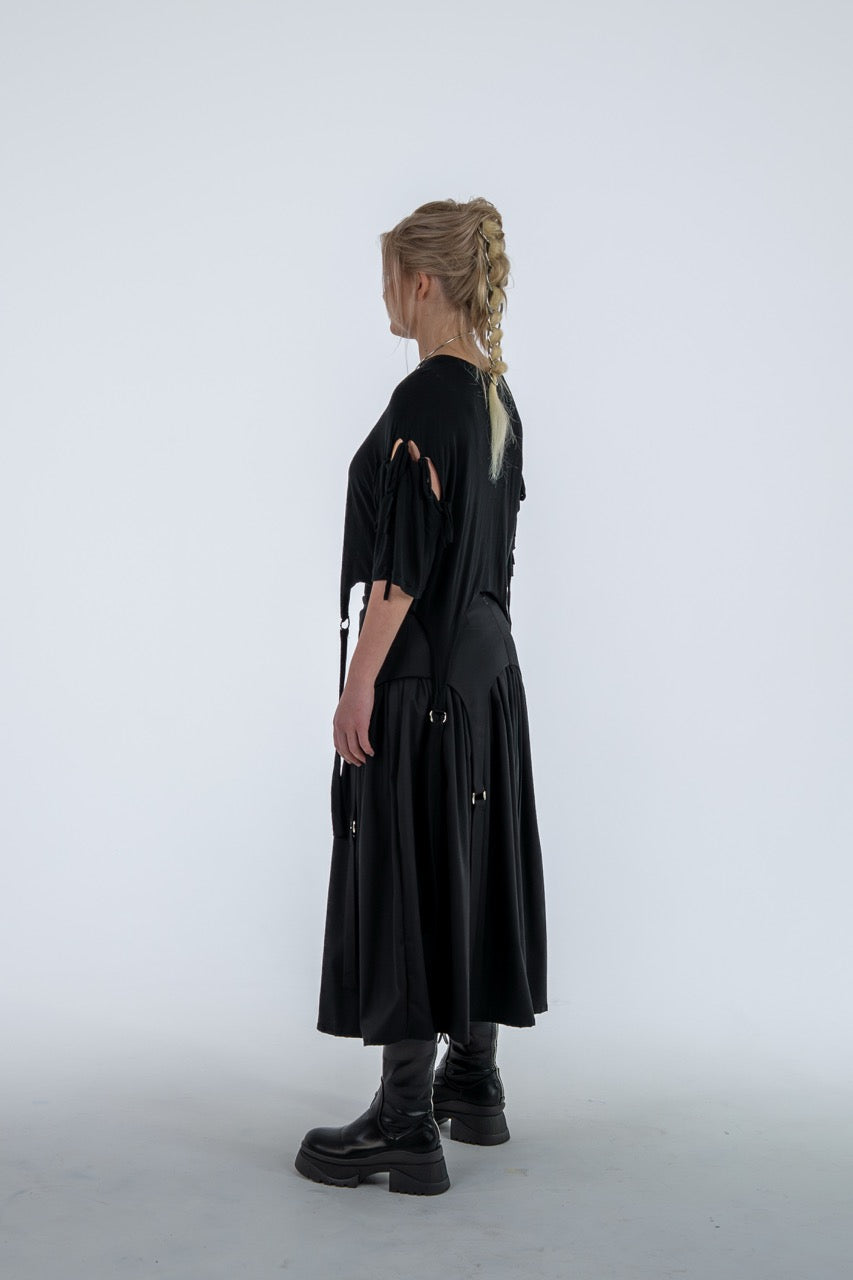 Person wearing a black outfit with cut-out details on a white background