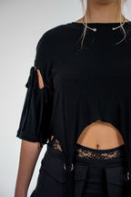 Black top with cut-out design on a plain background