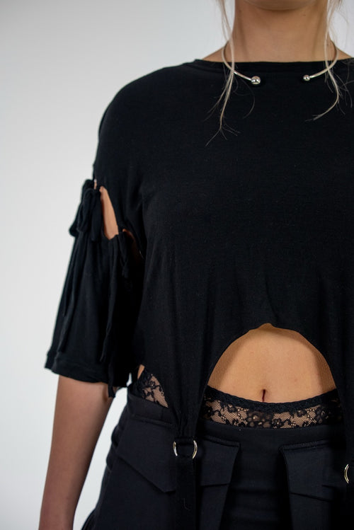 Black top with cut-out design on a plain background
