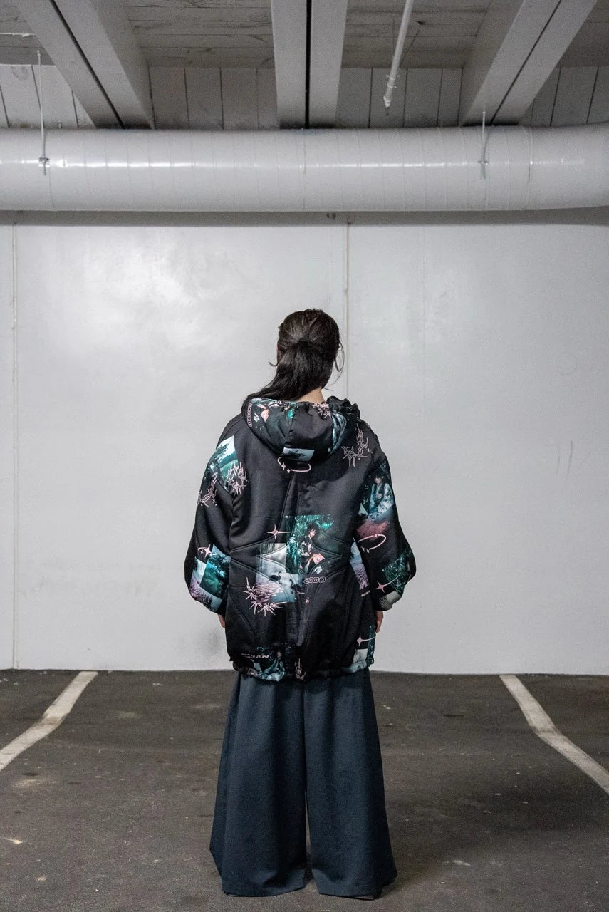 Person wearing a black jacket with colorful floral patterns in an indoor setting.