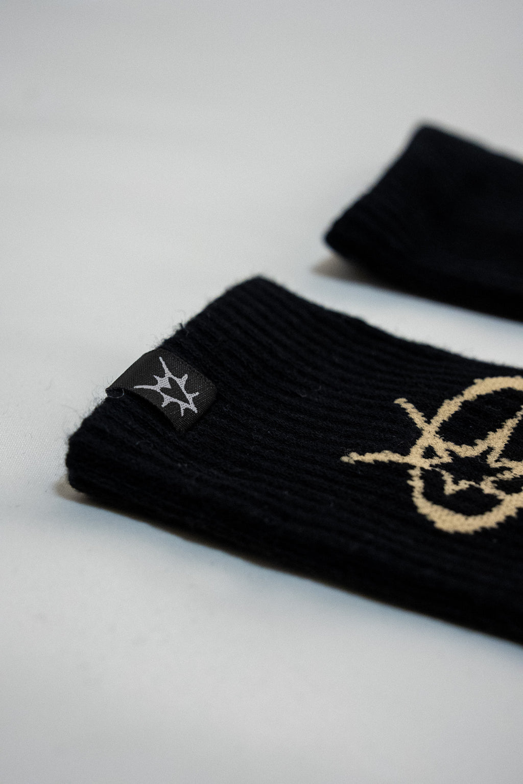 Black wristbands with gold logo on a light gray background