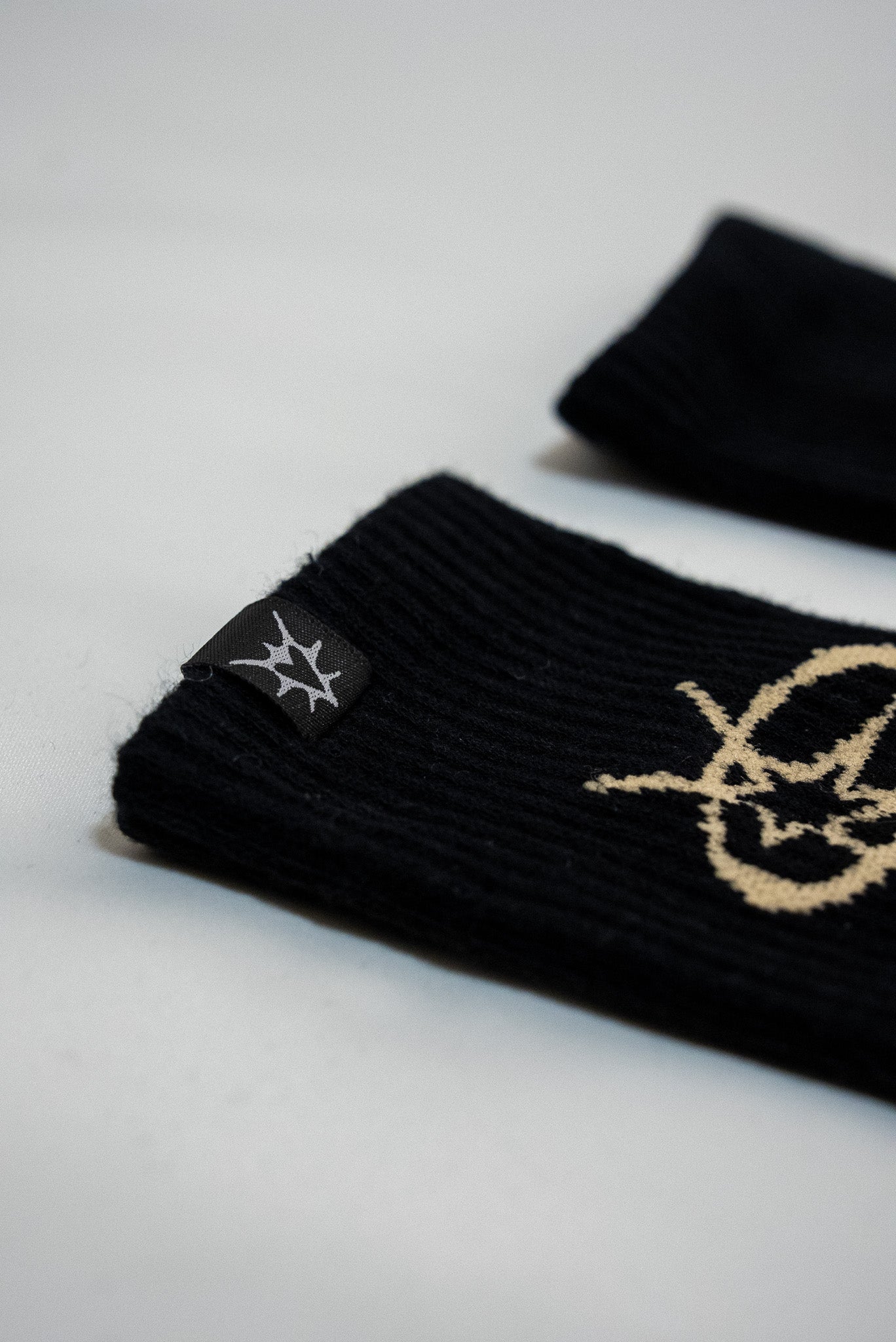Black wristbands with gold logo on a light gray background