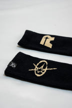 Two black socks with gold logos on a white background